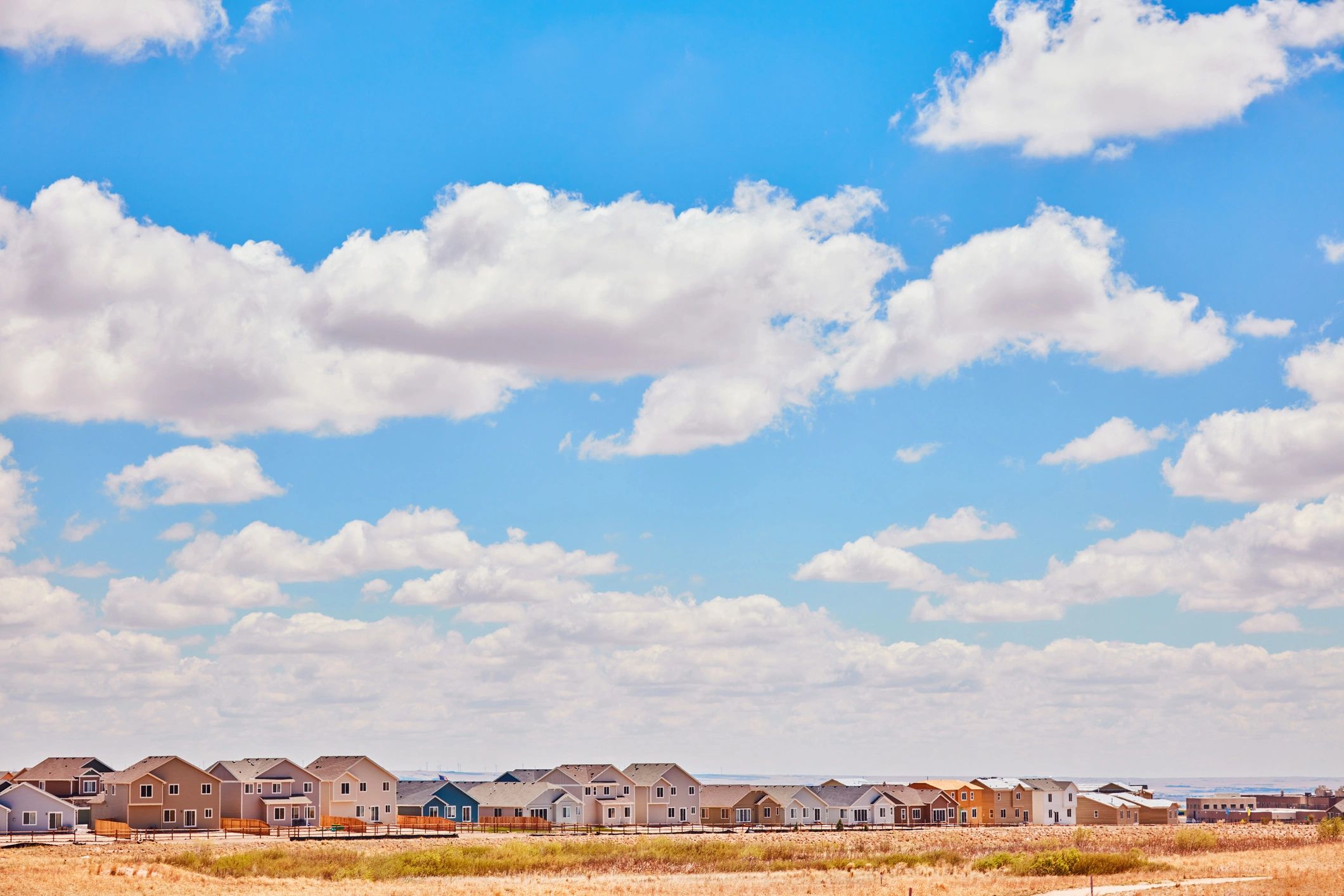 Row of modern townhomes under a bright sky